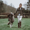 Grantham Sage Check Wool Jacket by Welligogs, full-length outdoor view on a model leading a pony, showing the tailored silhouette.