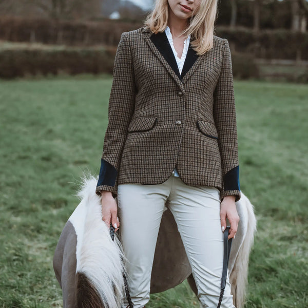 Grantham Sage Check Wool Jacket by Welligogs, buttoned front view outdoors showing the check pattern, trimmed flap pockets, and navy cuffs.
