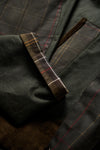 Close-up detail of the Barbour Icons Patch Bedale Wax Jacket showing the tartan patch lining, waxed cotton fabric, and corduroy trim at the cuff and pocket.