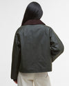 Person wearing a dark green jacket with a plain background