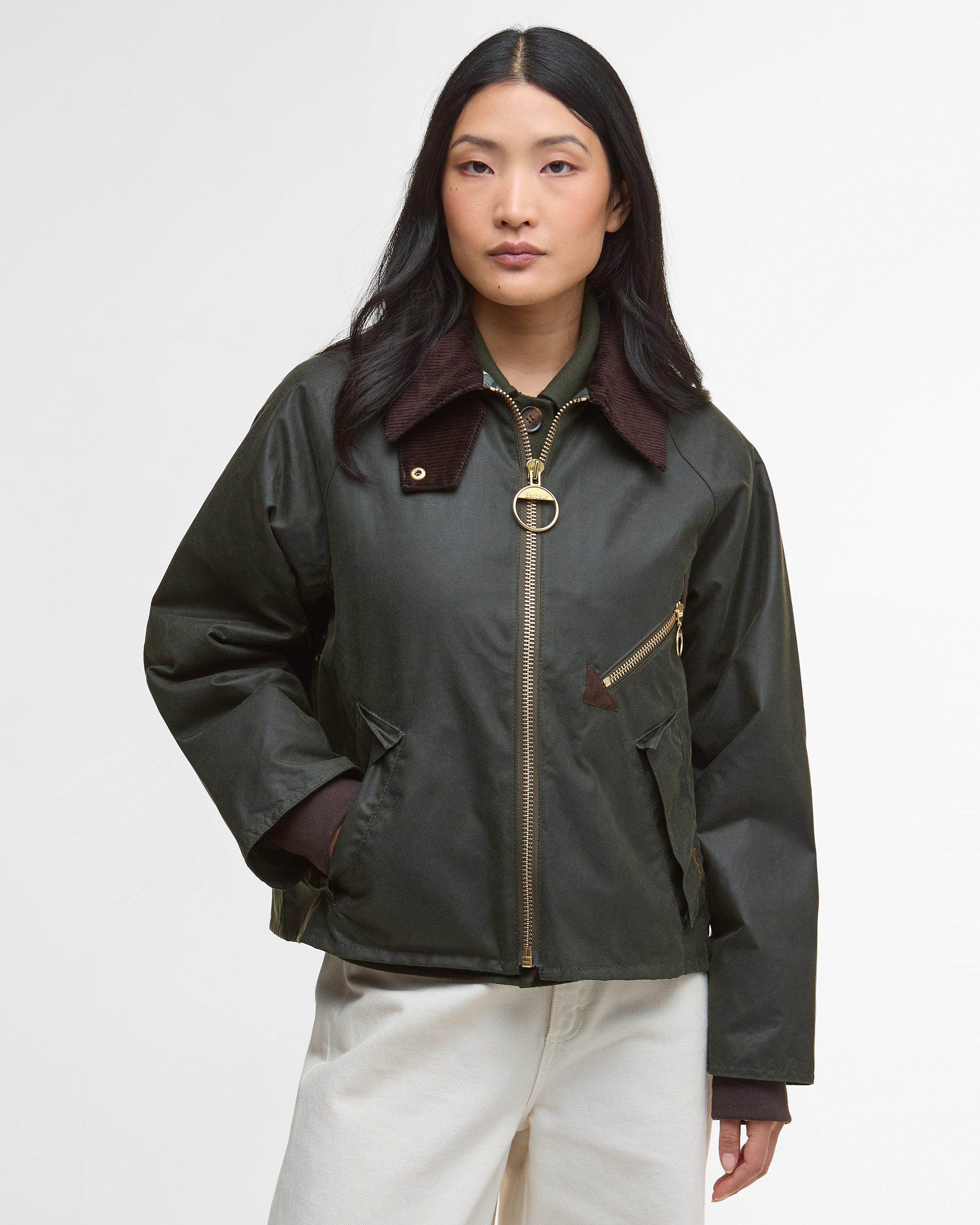 Woman wearing a dark green jacket with a brown collar on a white background