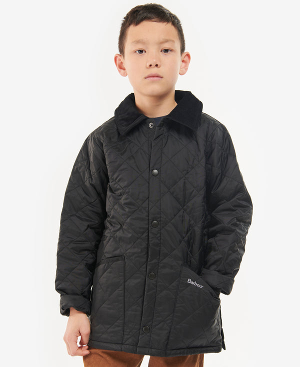 Child wearing a black quilted jacket on a white background
