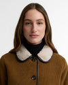 Woman wearing a brown coat with a black and white collar against a white background