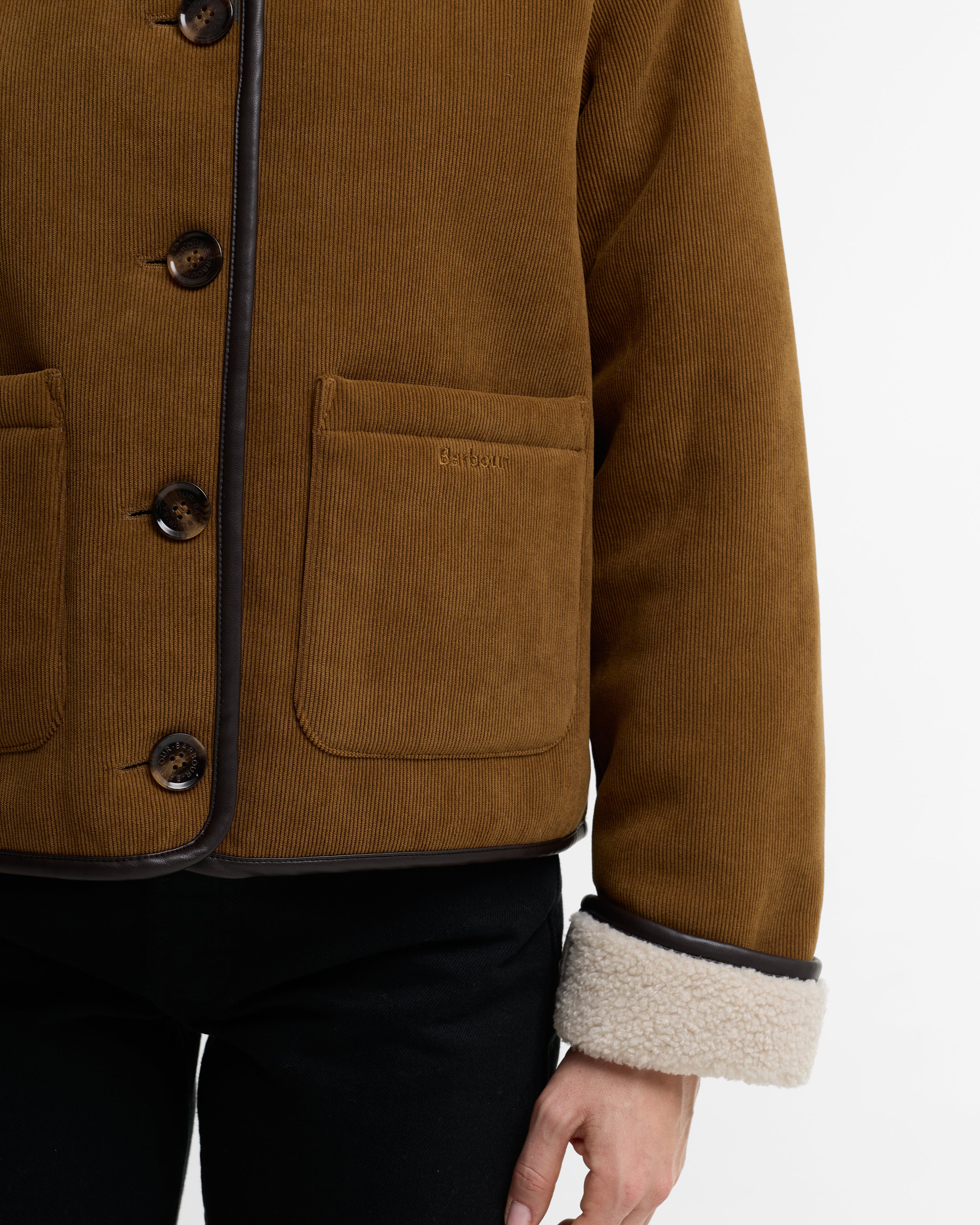 Brown corduroy jacket with button details on a white background