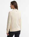 Woman wearing a cream-colored sweater on a white background