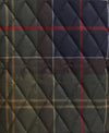 A close-up of a quilted fabric with a tartan plaid pattern in dark green, navy blue, brown, and red, featuring diamond-quilted stitching.