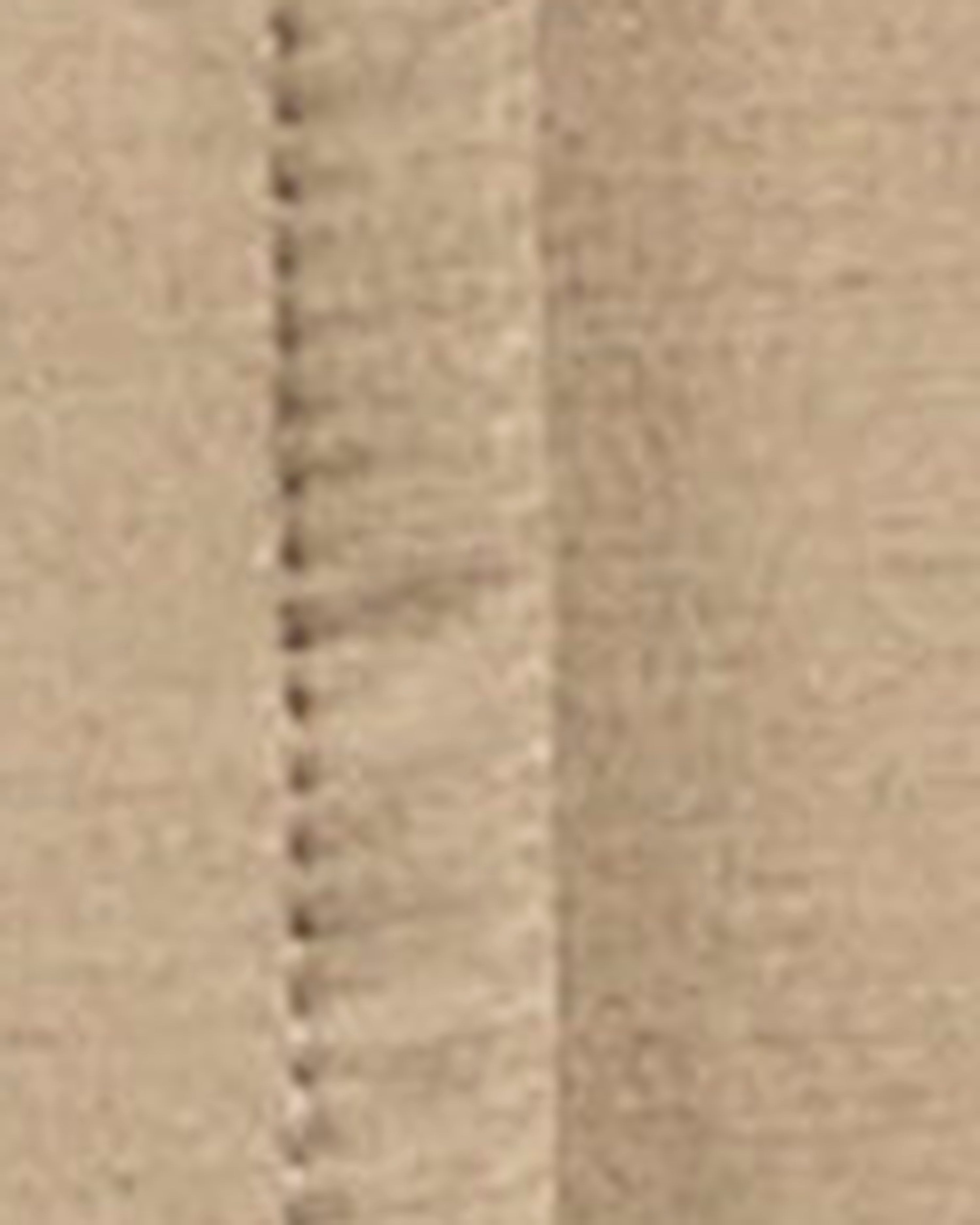 Close-up of a beige fabric surface with a visible stitched seam running vertically.