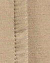 Close-up of a beige fabric surface with a visible stitched seam running vertically.