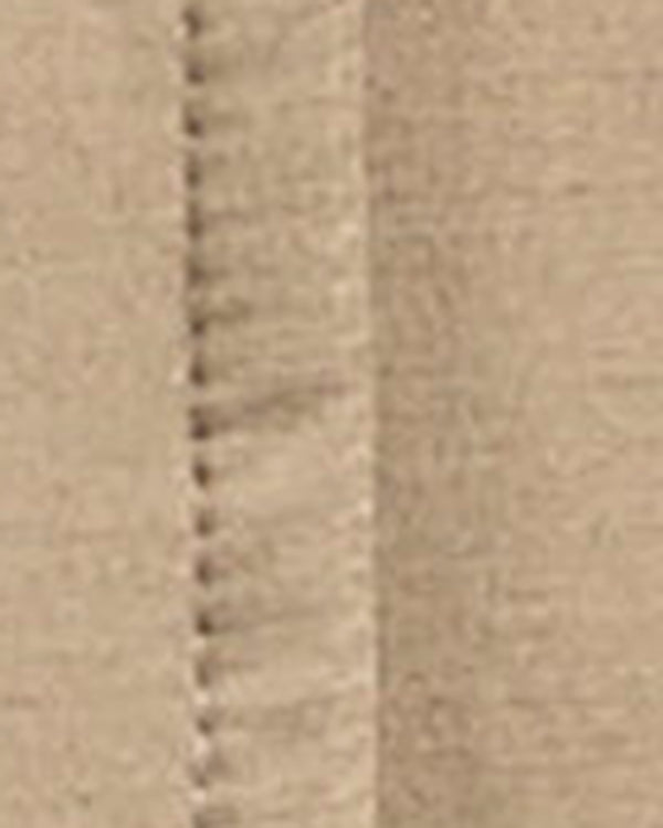 Close-up of a beige fabric surface with a visible stitched seam running vertically.