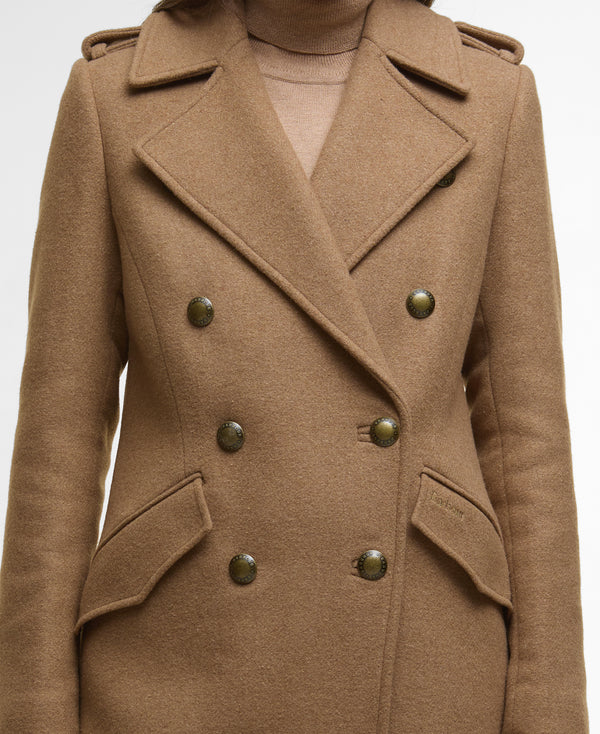 A close-up of a camel brown double-breasted coat with dark metallic buttons, worn over a matching beige turtleneck sweater.
