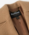 Close-up of a camel-colored wool coat with a visible Barbour brand label inside the collar.