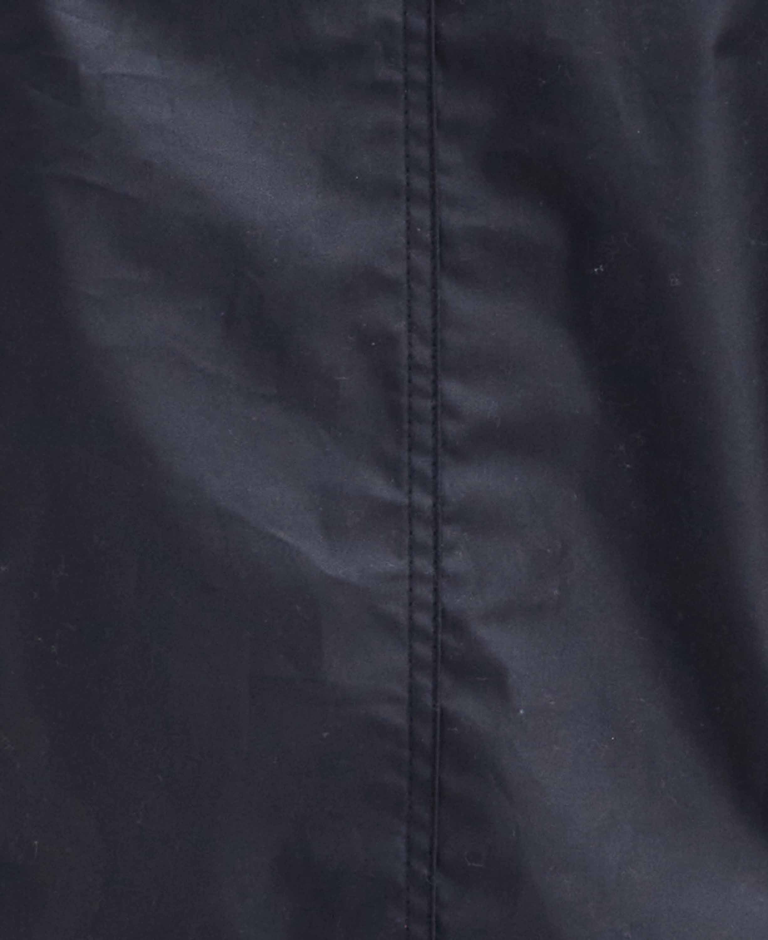 Close-up of a black fabric surface with a vertical seam running down the center.