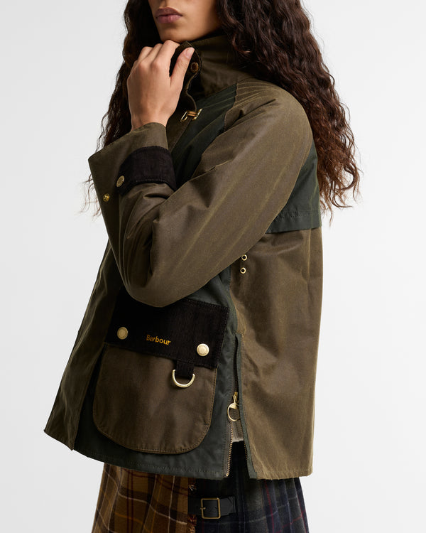 Side view close-up of the Barbour Hazelwood Wax Jacket showing the corduroy patch pocket with Barbour embroidery and gold D-ring, corduroy cuff trim, and side zip.