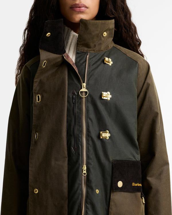 Close-up of the Barbour Hazelwood Wax Jacket open to show the gold Barbour ring zipper, gold hook-and-eye closures, corduroy Barbour-logo pocket, and two-tone waxed cotton paneling.