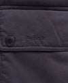 Close-up of a dark navy quilted fabric jacket with a flap pocket, a snap button, and the Barbour logo embroidered on the front.