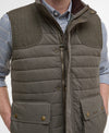 Brown quilted vest worn over a checkered shirt on a white background