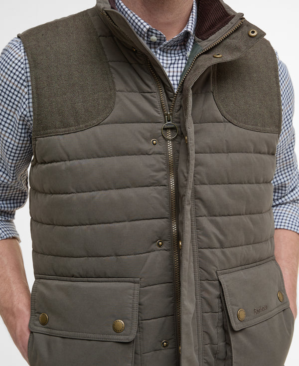 Brown quilted vest worn over a checkered shirt on a white background