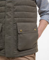Close-up of a person wearing a Barbour quilted vest with a visible brand logo.