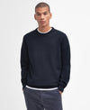 Man wearing a navy blue sweater with a white collar on a light gray background
