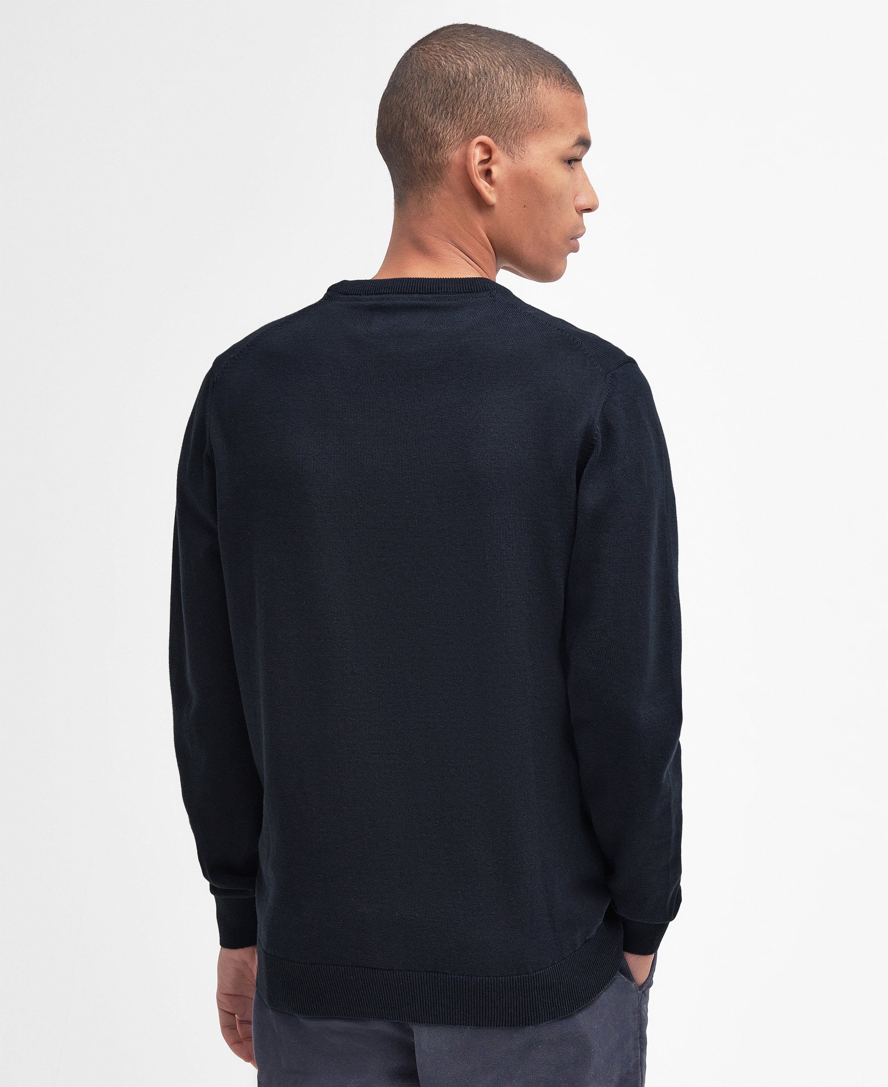 Man wearing a navy sweatshirt on a light gray background