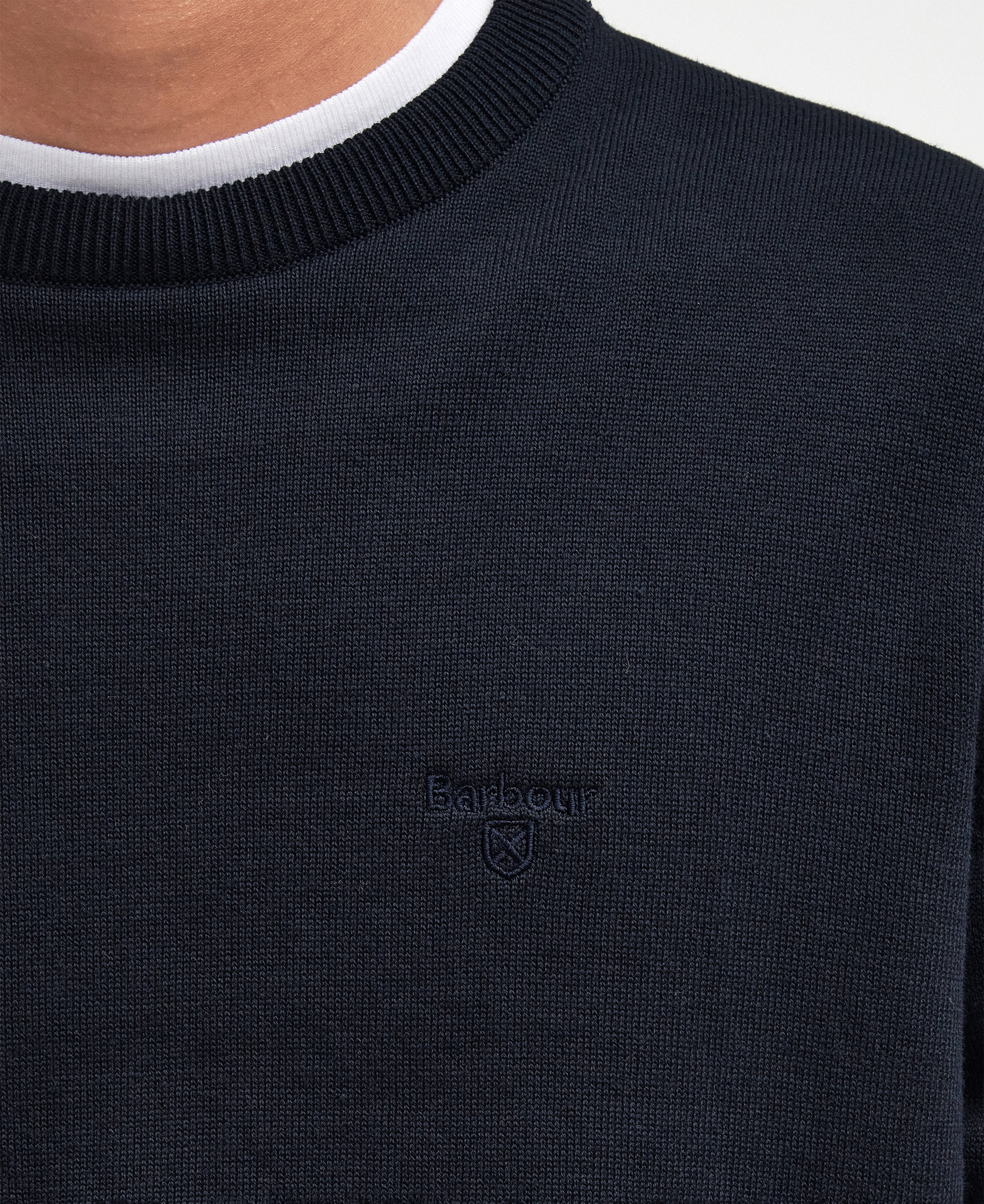 Navy sweater with Barbour logo on a white background
