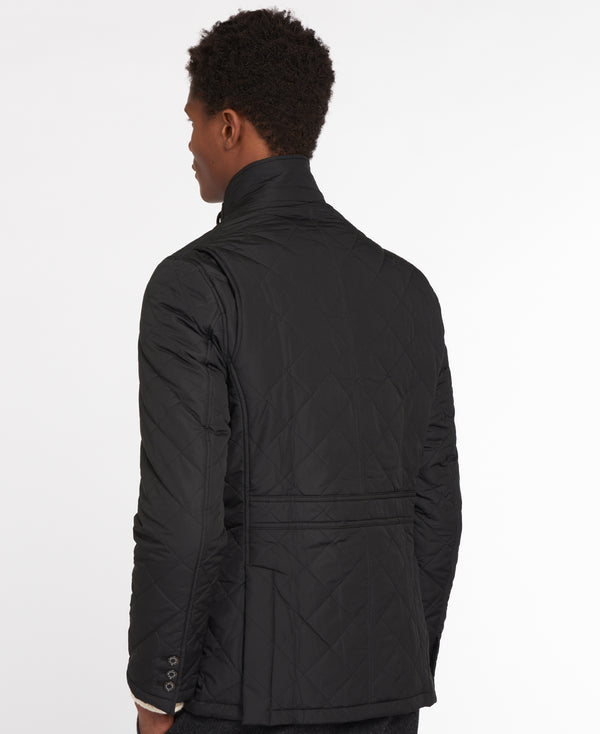 A man shown from the back wearing a black quilted jacket with a high stand-up collar, photographed against a clean white studio background.