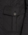 Close-up of a black quilted jacket with a diagonal flap pocket featuring a button and Barbour embroidery.