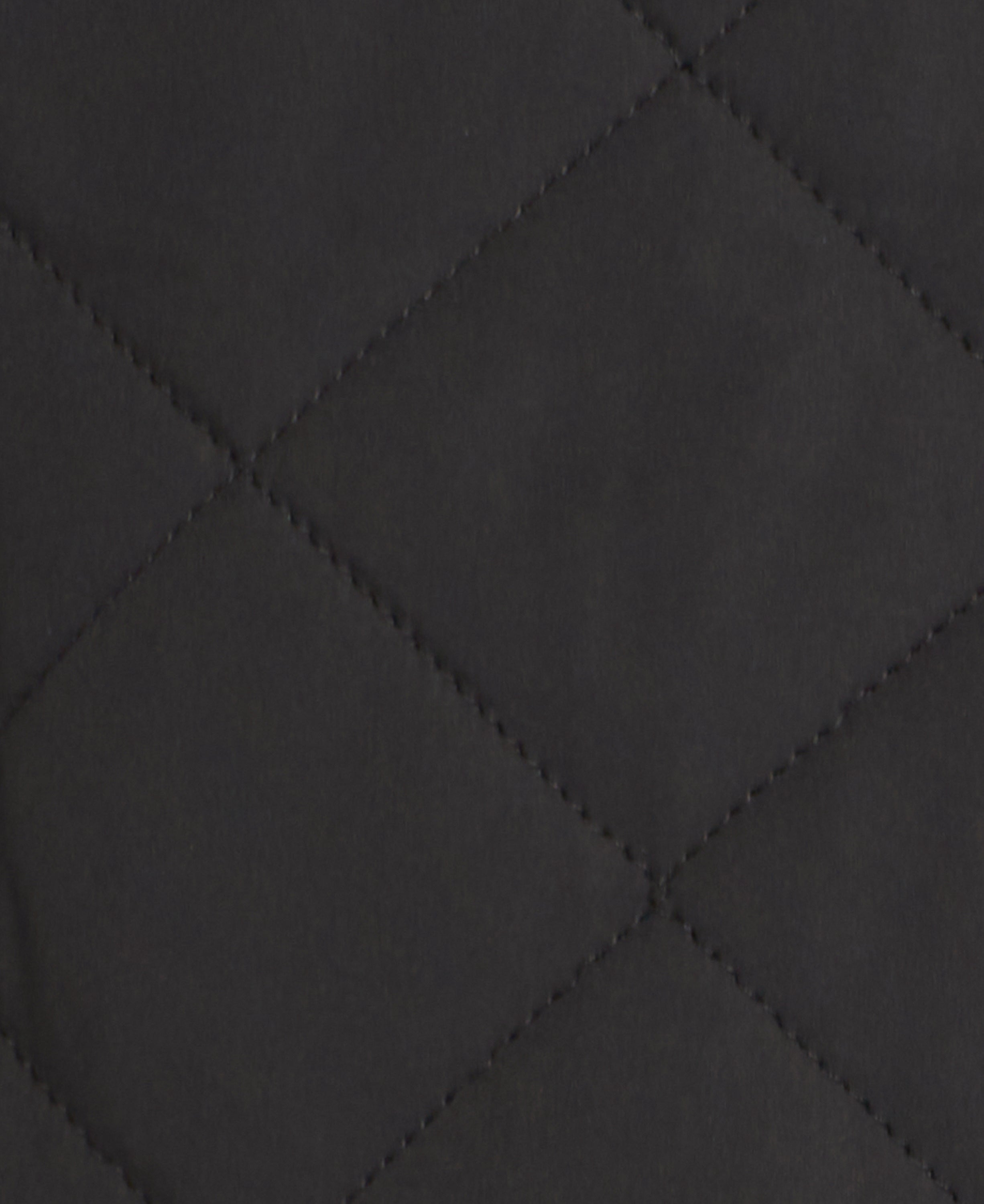 Close-up of a dark charcoal gray quilted fabric with stitched diamond patterns.