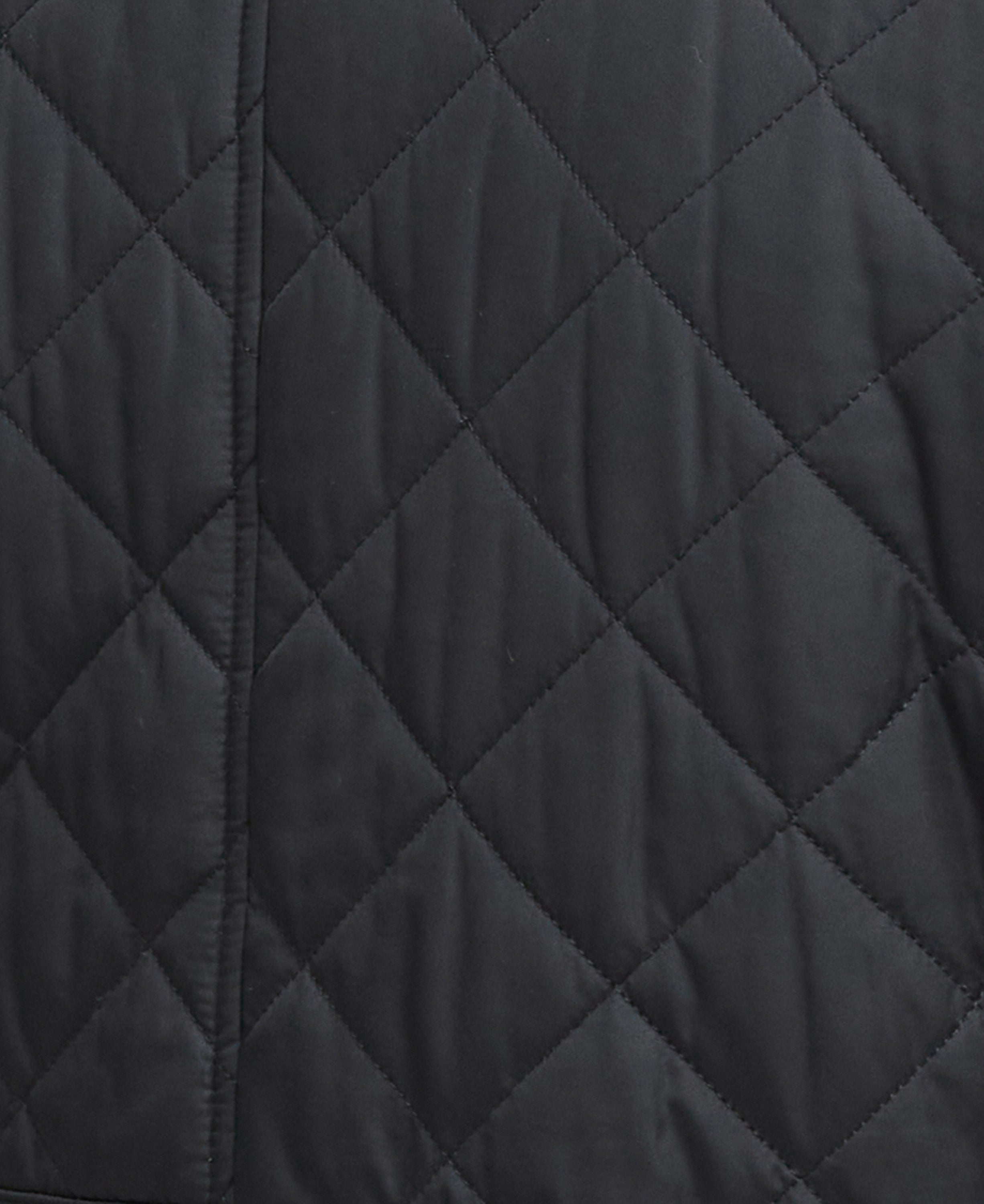 Close-up of a black quilted jacket fabric showing a diamond patterned stitching.