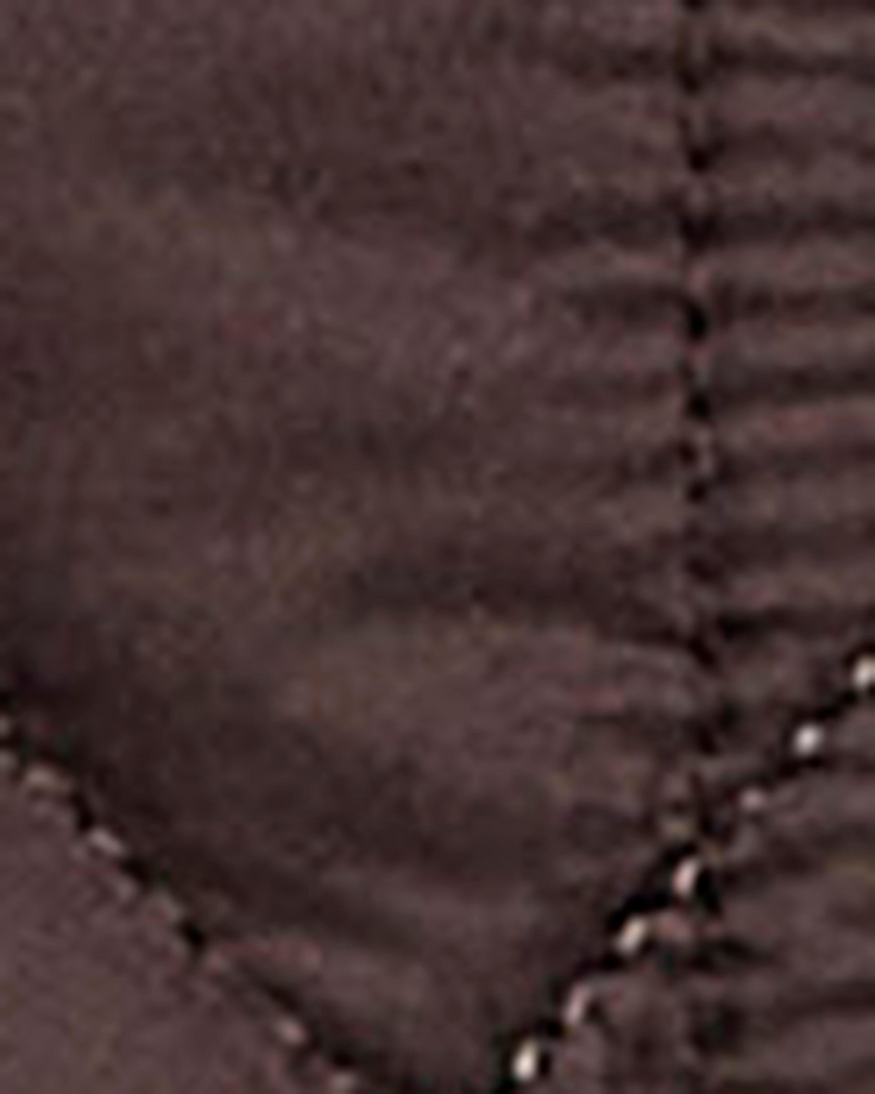 Close-up of a dark brown quilted fabric with visible stitching details.