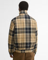 A man viewed from behind wearing a Barbour Tartan Showerproof Blouson Jacket with brown pants.
