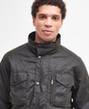 Model wearing the Barbour Sapper Wax Jacket showing the tall collar fastened, vertical dark brass zipper pocket.
