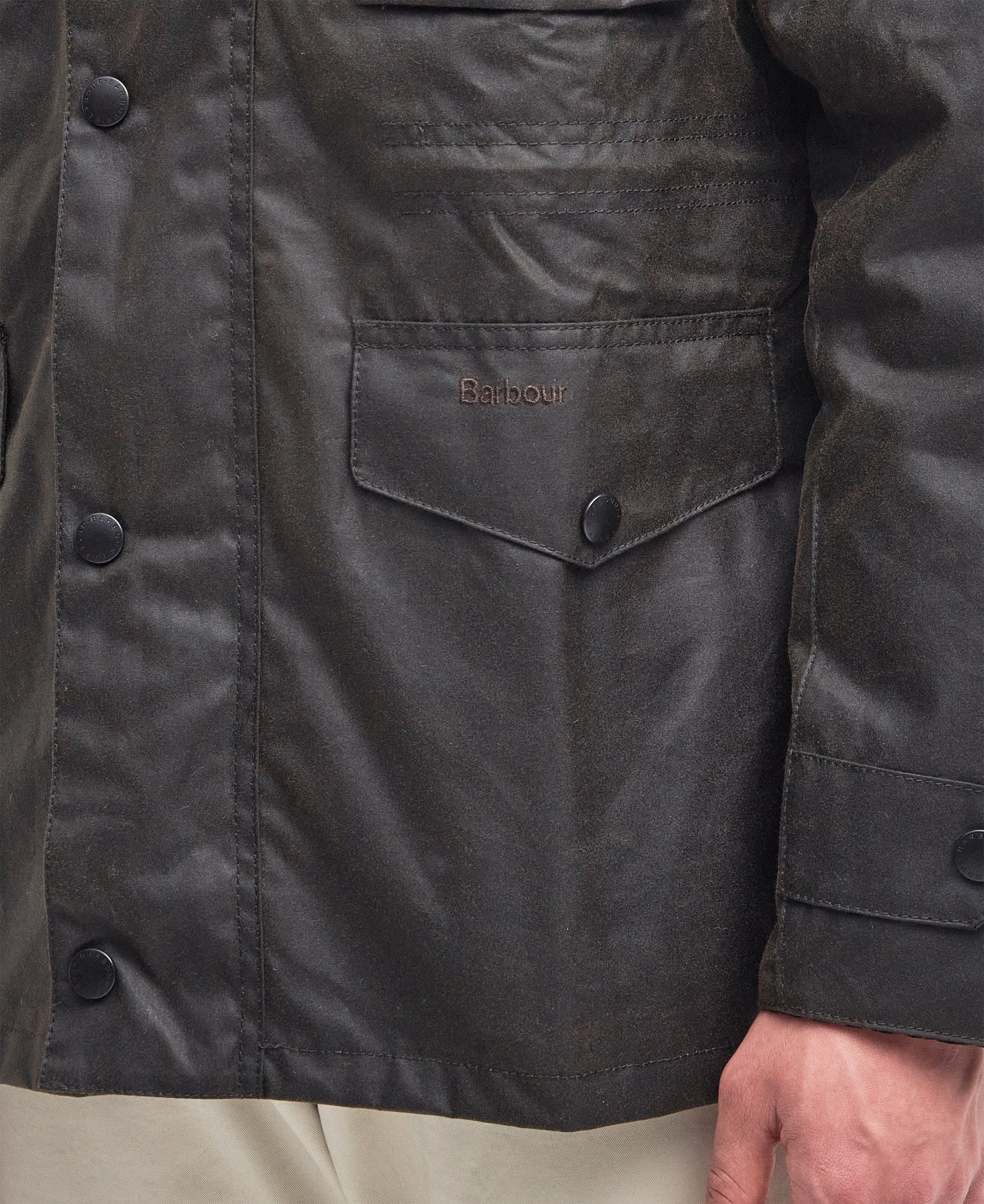 Detail shot of the Barbour Sapper Wax Jacket pocket and stitching.