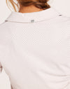 Close-up of a white shirt with a subtle pattern worn by a person.