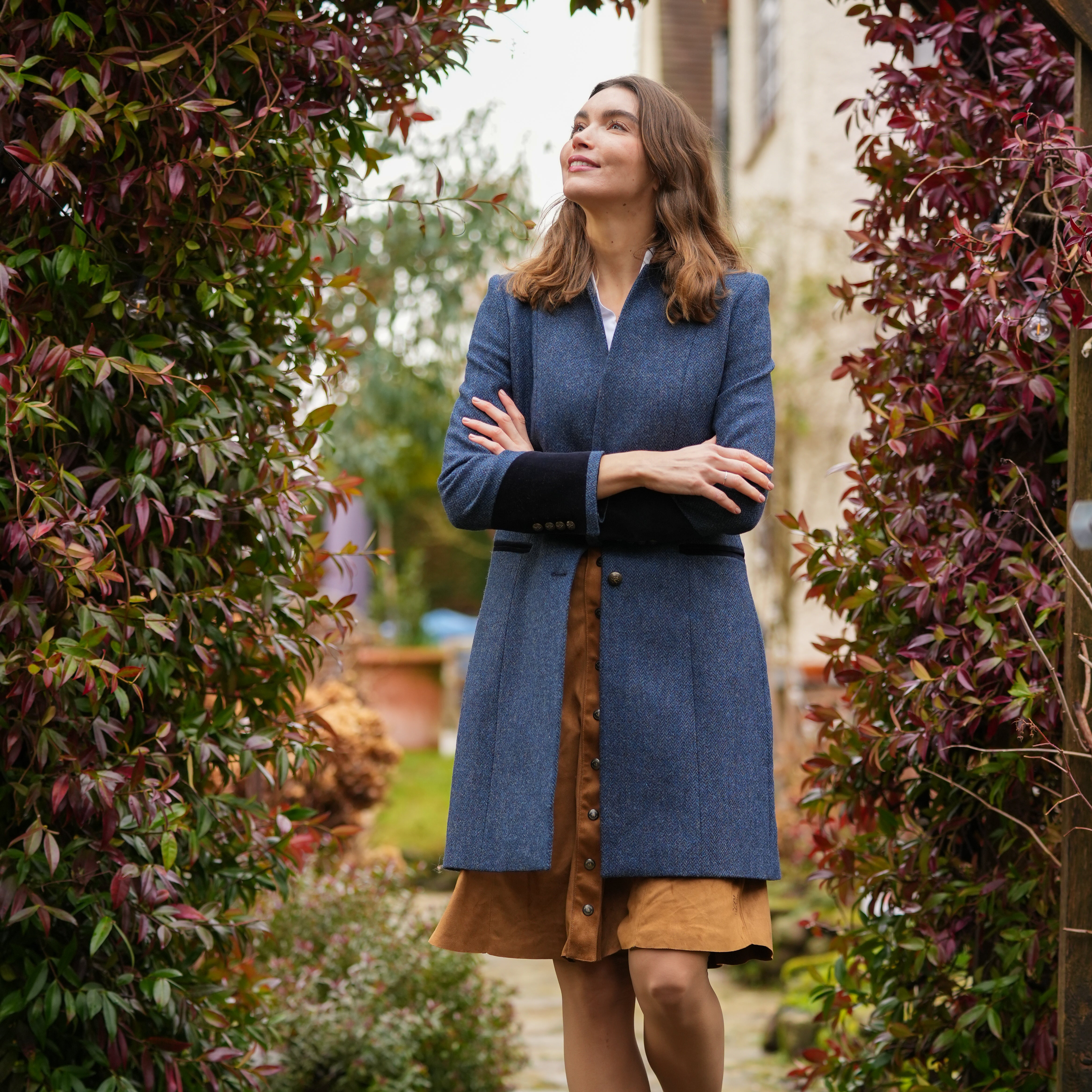 Oxford Navy Coat by Welligogs, outdoor front view with arms crossed and contrast cuffs visible.
