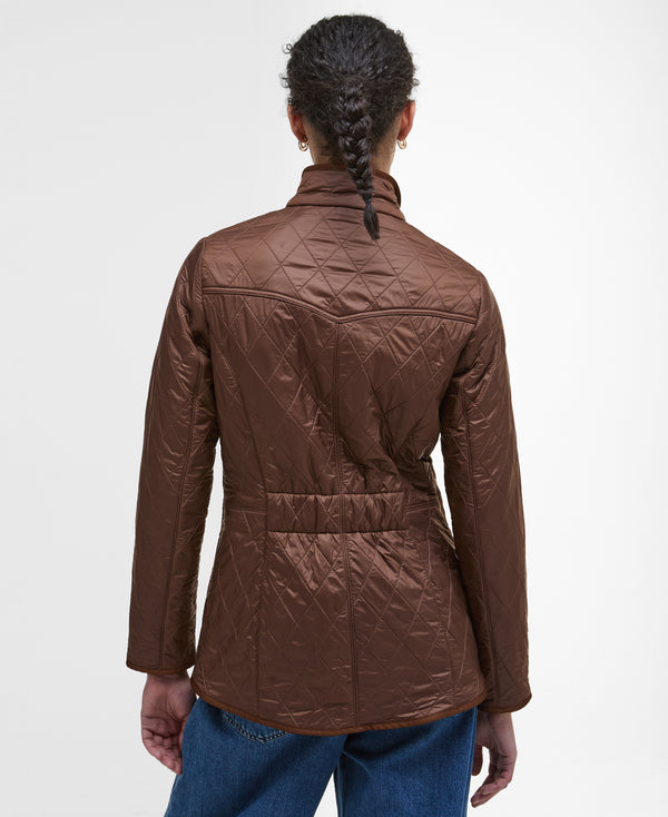 Person wearing a brown quilted jacket on a white background