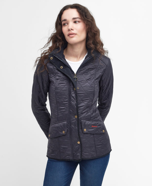 Woman wearing a navy quilted jacket on a light gray background
