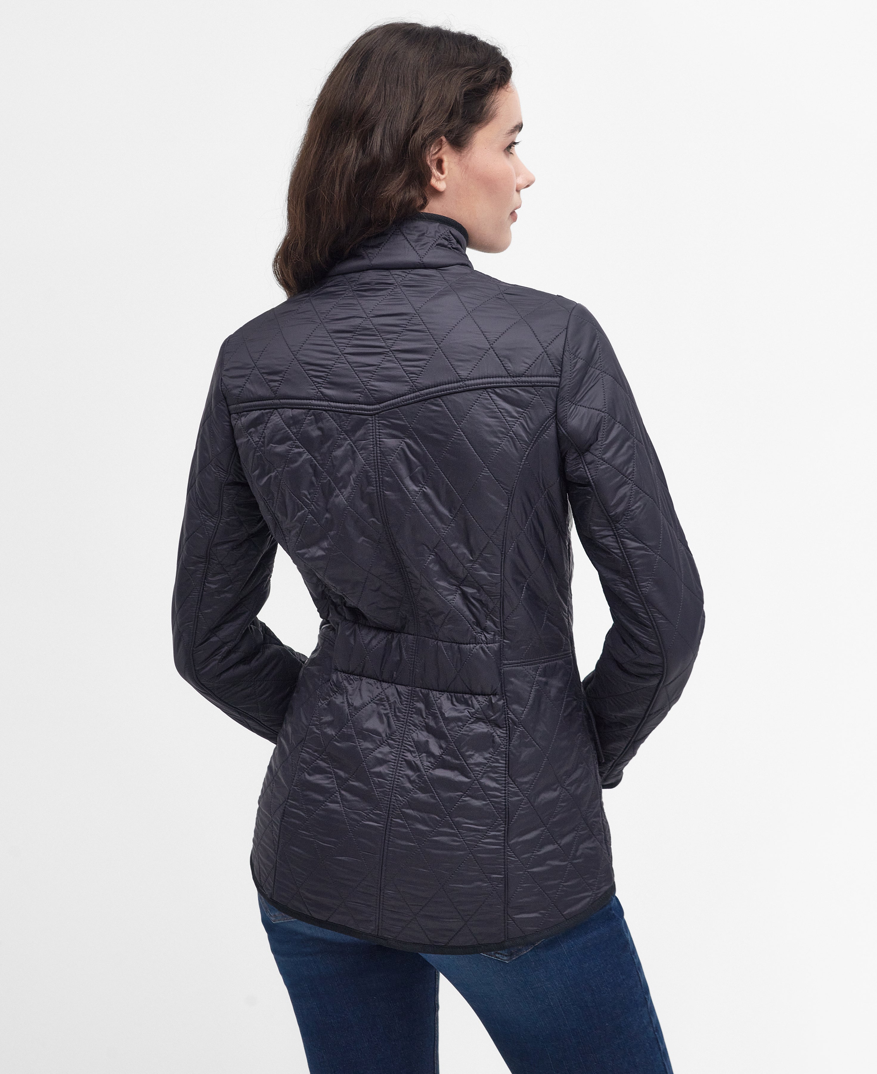 Woman wearing a navy quilted jacket on a white background