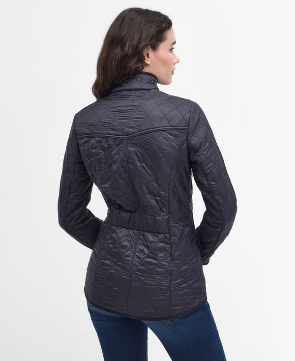 Woman wearing a navy quilted jacket on a white background